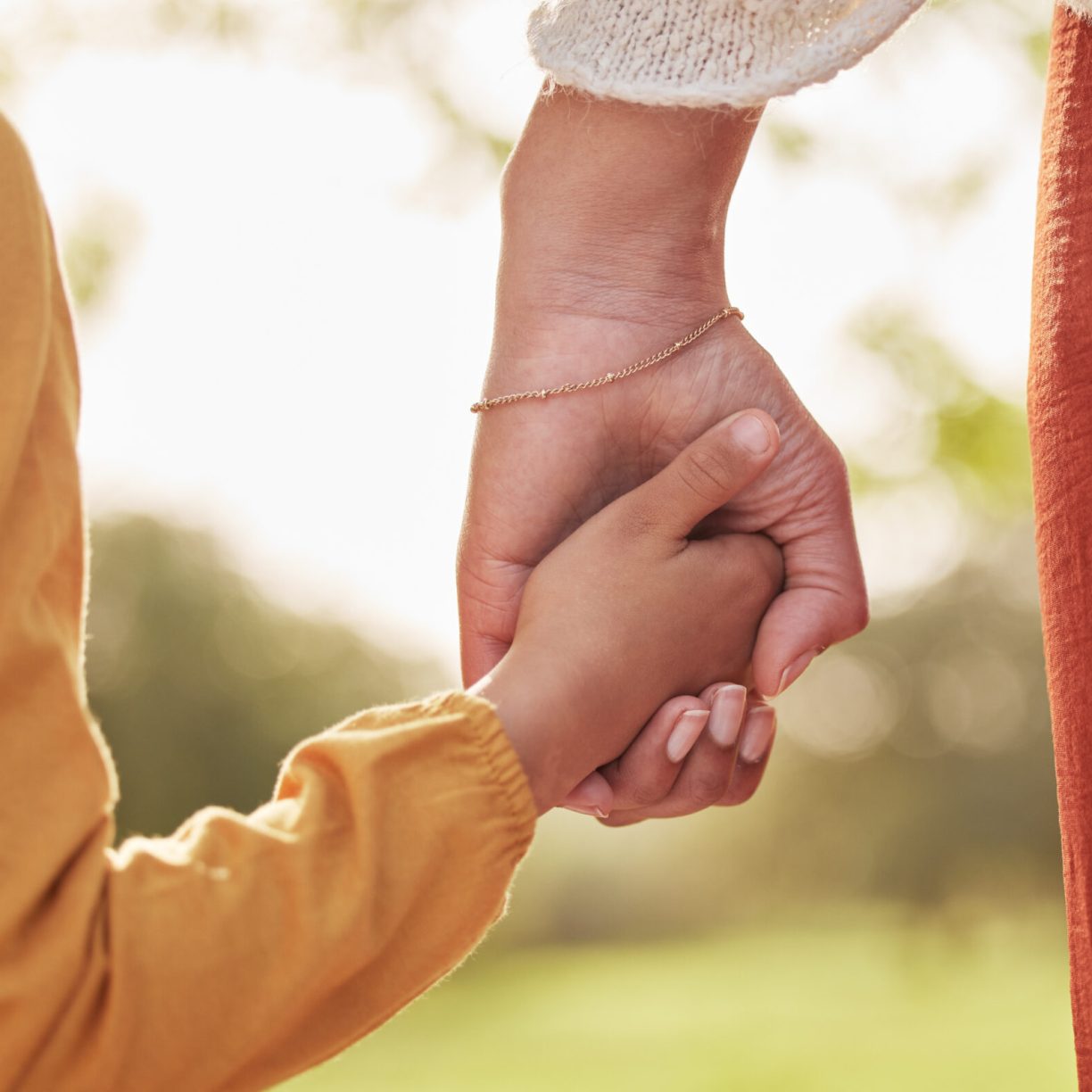 un parent mamant entrain de tenir la main d'un enfant